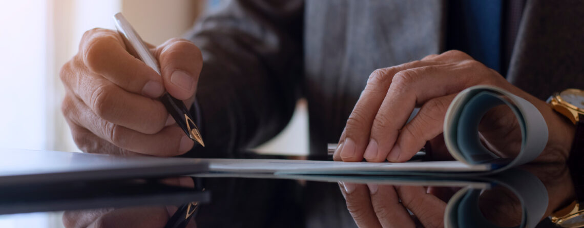 Man signing documents as desk