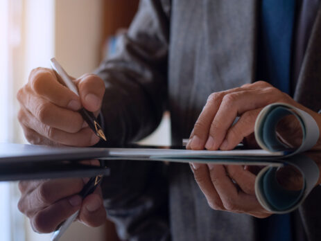 Man signing documents as desk