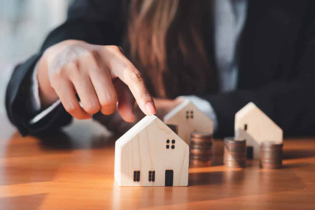 Woman pointing to small wooden home