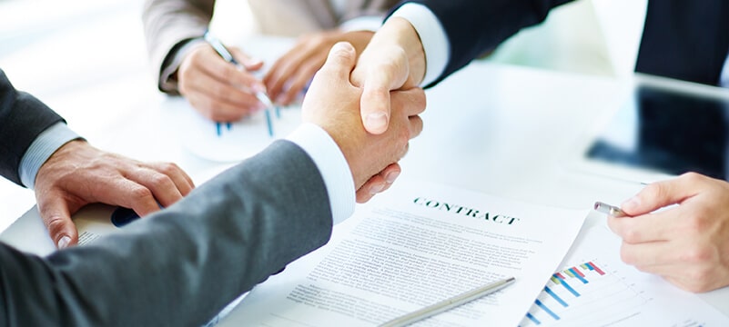Image of a hand shake after signing documents